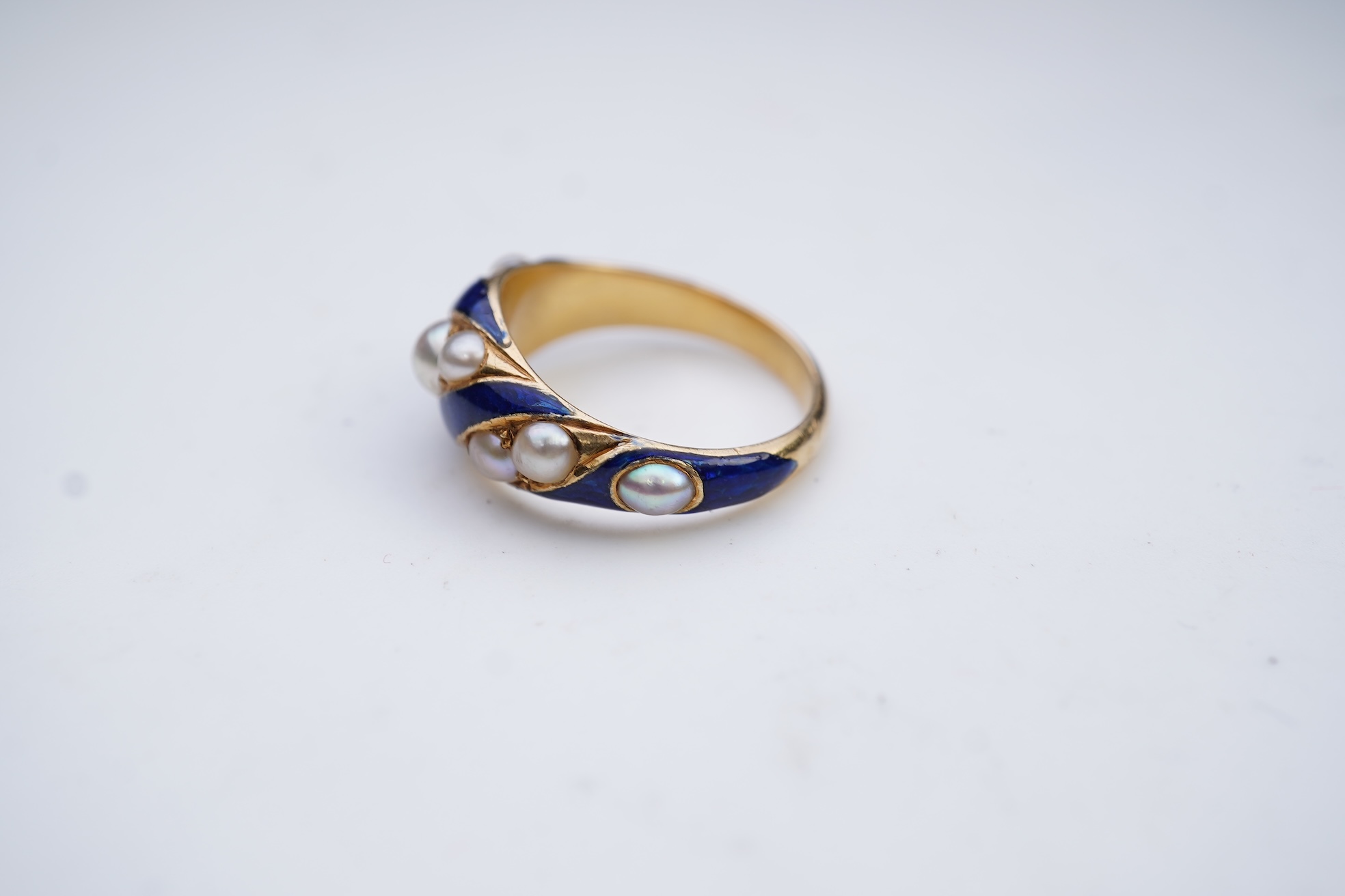 A Victorian half pearl and blue enamel ring, mid 19th century